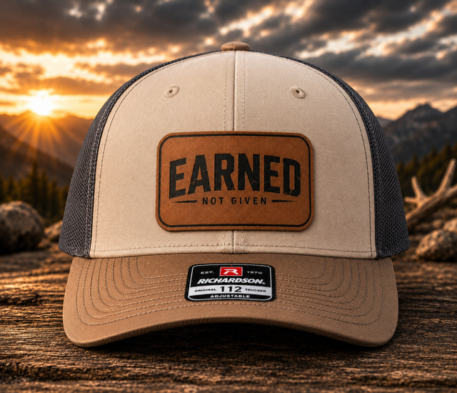 Tri Color mesh-back trucker hat with a rawhide leatherette patch engraved with the Earned Not Given design.